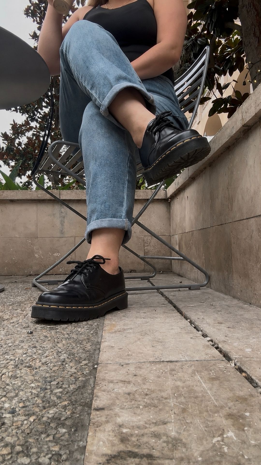 Docs, cuffed denim and a coffee on a patio